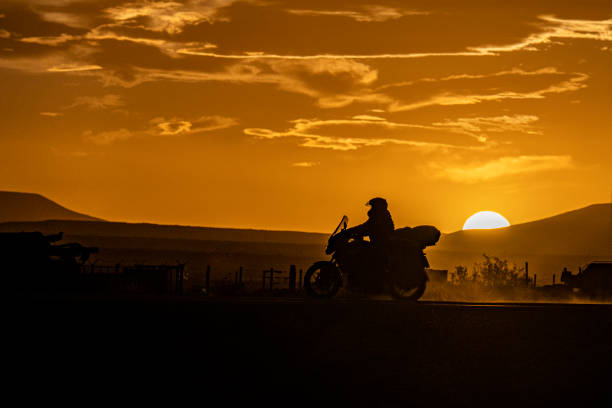 istock Motorcyclist silhouette at sunset. 1581373398