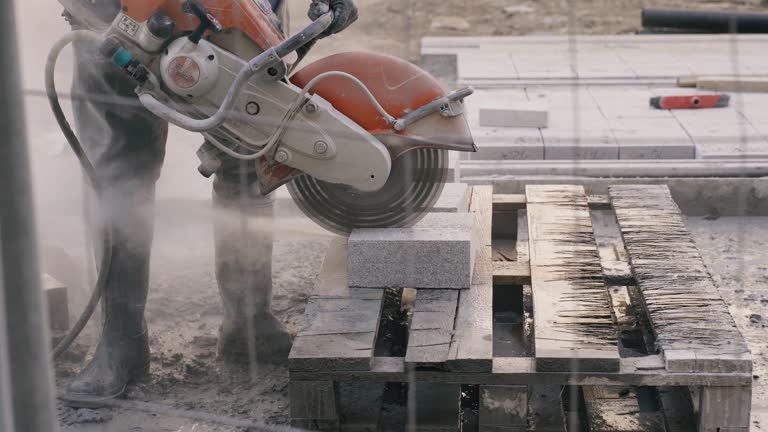 A worker cuts paving slabs, close-up.