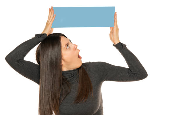 istock Beautiful shocked woman holding a blank blue billboard 1581410535