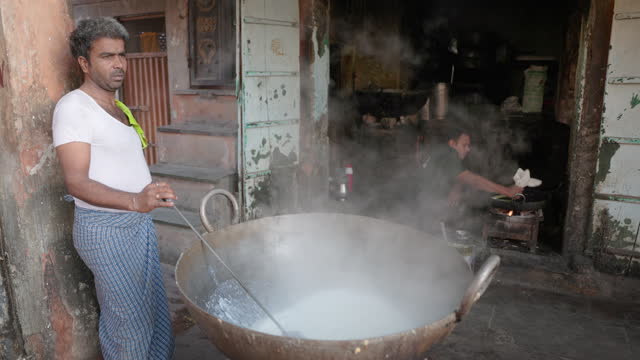 Indian street vendor preparing a mawa - dried evaporated milk solids, Jaipur