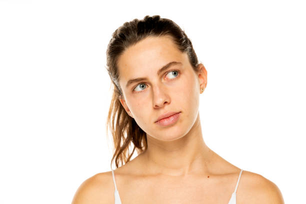 Image of thinking young lady with blue eyes, posing isolated over white background. Looking aside.