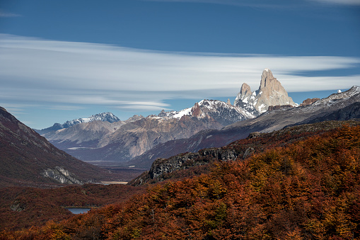Mount Fitz Roy, in El Chaltén, Santa Cruz, Argentina, with clouds in the blue sky above it.