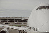 Partial view of a Boeing 747 parked at the gate of an airport