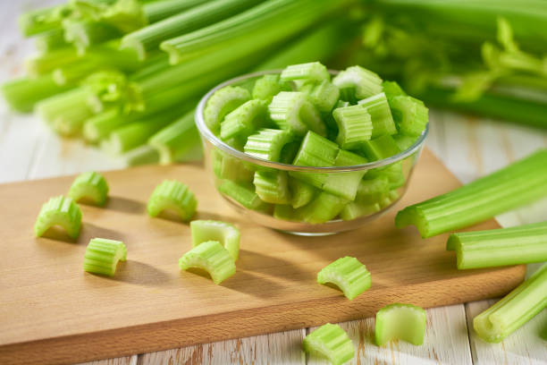 istock Sliced fresh celery or celery stalk on cutting wooden board. 1581488788