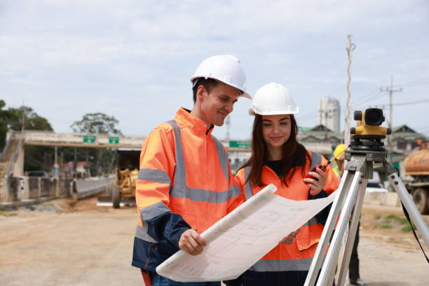 istock Portrait of two engineers holding a blueprint and looking at a new construction project 1581513984
