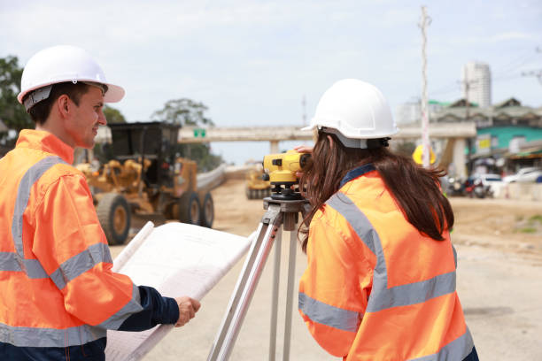 istock Portrait of two engineers holding a blueprint and looking at a new construction project 1581514494