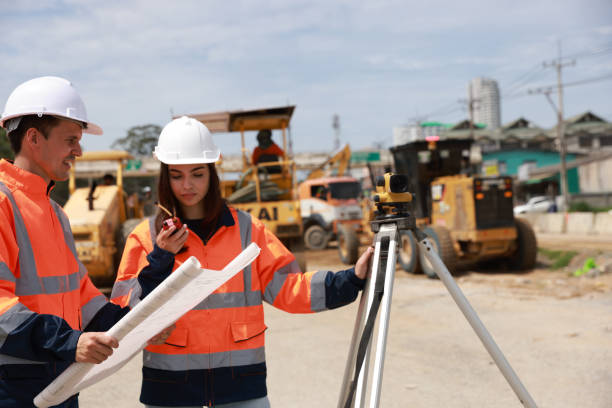 istock Portrait of two engineers holding a blueprint and looking at a new construction project 1581514495