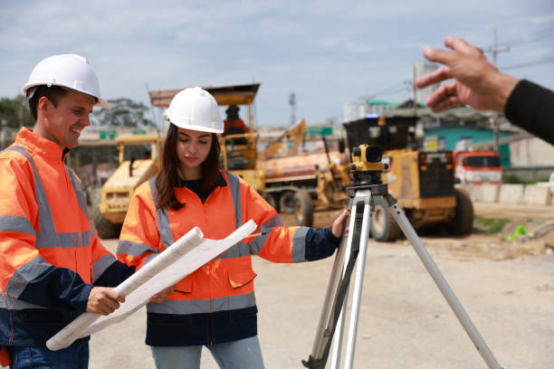 istock Portrait of two engineers holding a blueprint and looking at a new construction project 1581514497