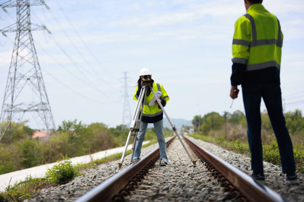 a couple of civil engineer work at the construction site  to progress the building project on the railway