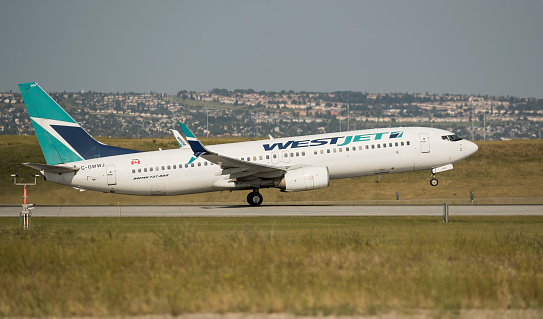 Calgary, Alberta, Canada. July 22, 2023. A WestJet Airlines Boeing 737, with identification C-GWWJ, taking off from Calgary International Airport