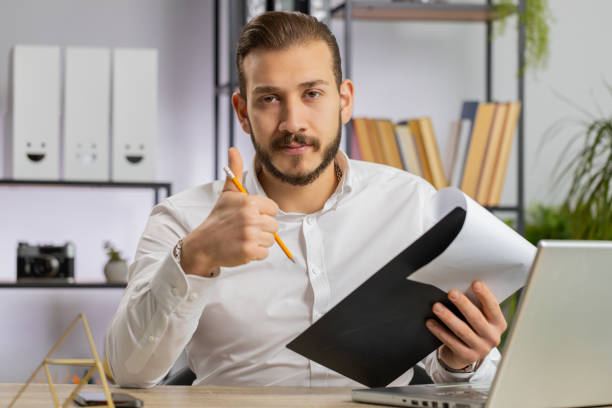 istock Business man reading business contract, planning project, analyzing resume, good paperwork results 1581536555