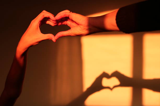 istock Mother and Son Forming a Heart Shape Shadow on Wall 1581536952