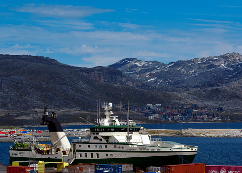 Nuuk / Godthåb, Sermersooq municipality, Greenland: Fishing trawler Markus (IMO 9826706 ) in Nuuk Harbor, with mountains in the background. Super trawler of the stern type, shrimper vessel, fish factory ship / freezer. Designed by Rolls-Royce and built by CNP Freire shipyard in Galicia, operated by Qajaq trawl. Greenland's economy is highly dependent on the fishing industry, employing over 10% of the population and contributing to more than 25% of GDP and over 80% of exports - Nuuk bay.