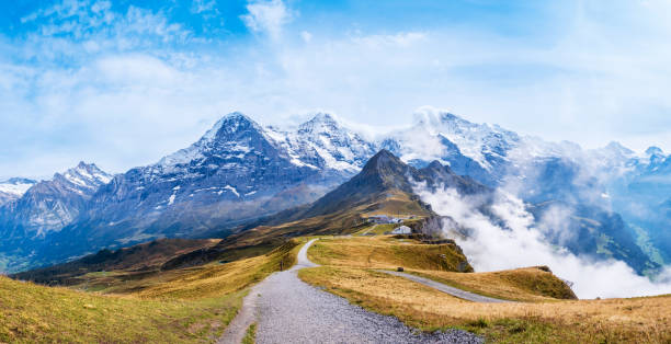 jesień w alpach szwajcarskich. szlak turystyczny na szczycie mannlichen w pobliżu wengen i lauterbrunnen w szwajcarii. pasmo górskie ze szczytami eiger, monch, jungfraujoch i jungfrau w chmurach. dolina grindelwald - wengen mountain peak eiger field zdjęcia i obrazy z banku zdjęć