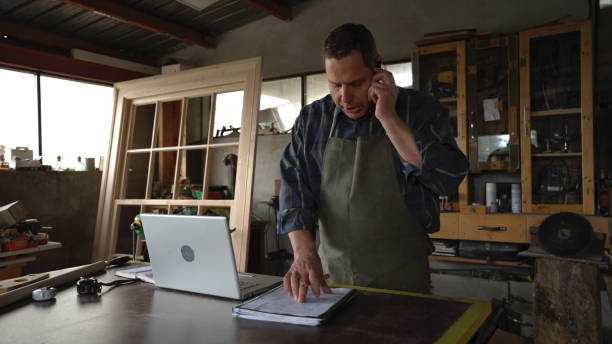 istock Carpenter working in his workshop.Small business owner. 1581618834