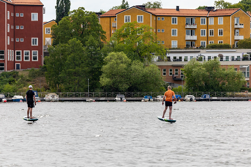 Stockholm, Sweden June 17, 2023 People riding electric surfboards, an e-foil, in the downtown.