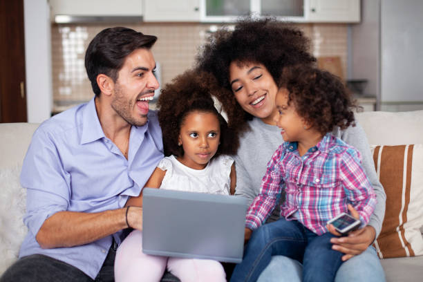 istock Happy family with little kids enjoying using laptop computer together 1581618988