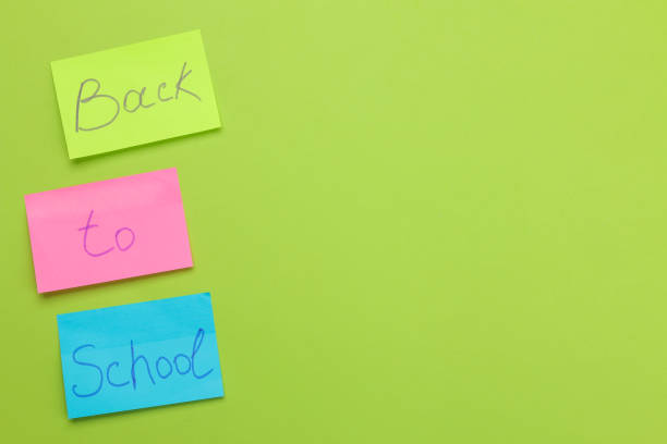 istock back to school. stationery text on bright multi-colored stickers on a bright green background. top view 1581619338