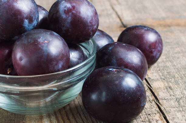istock Ripe plums in bowl on a wooden table 1581619397