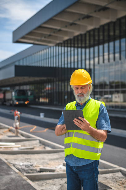 istock Serious Mature White Male Construction Worker Using With A Digital Tablet 1581631823