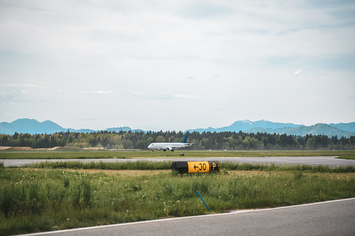 Commercial airplane moving towards a runway at the airport. Beautiful Alps in the background.