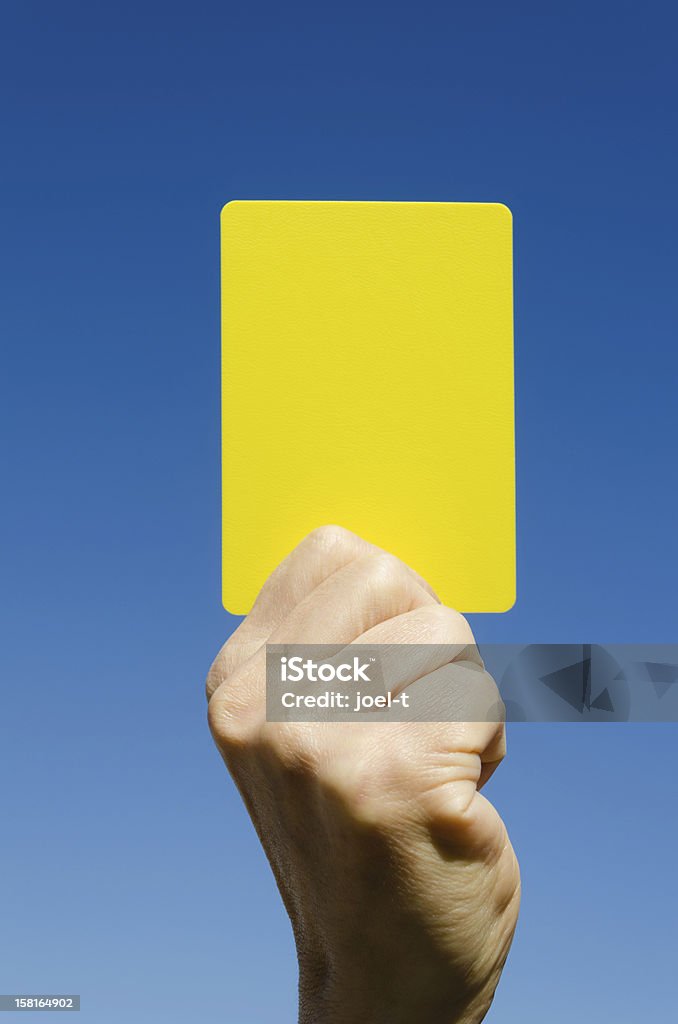 Żółta kartka w ręce przeciw błękitne niebo - Zbiór zdjęć royalty-free (Żółta kartka)