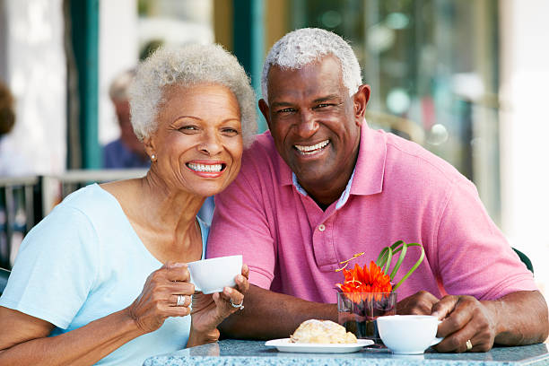 Retired Couple Sitting Outdoors At Home Having Morning Coffee Together Stock Photo - Download Image Now - iStock