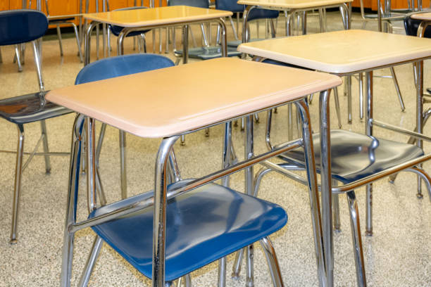 istock Example of an empty nondescript US High School Classroom with desks, Window and black board. 1581733411