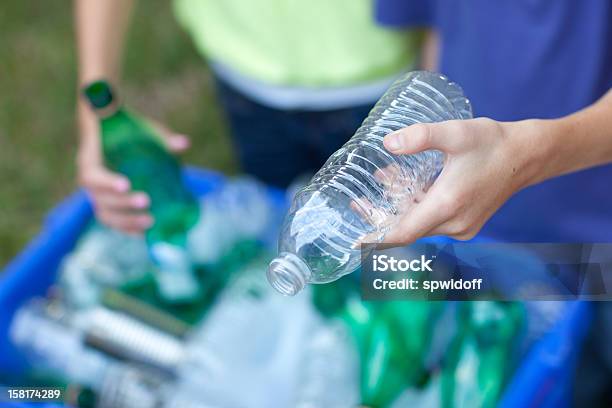 Hands Placing Bottles In Recycling Bin Stock Photo - Download Image Now - Recycling, Plastic, Bottle