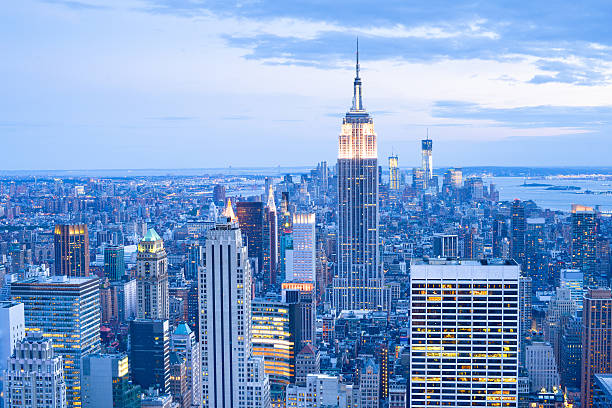 empire state building e o horizonte da cidade de nova york ao anoitecer - big apple - fotografias e filmes do acervo