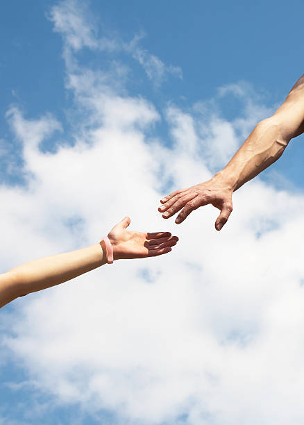 gesture help two arms stretching towards each other to help against the blue sky couple hope sky blue stock pictures, royalty-free photos & images
