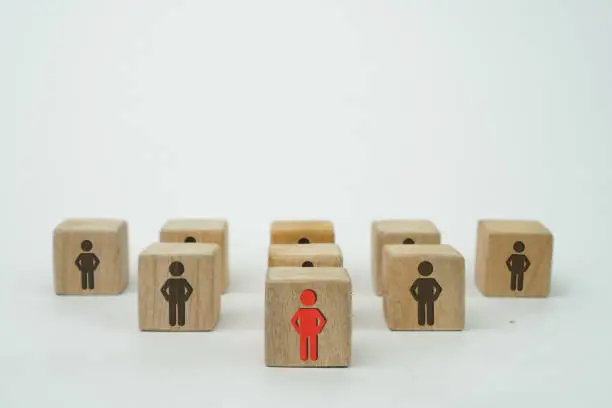 Photo of leadership concept, neatly arranged wooden cubes or dice with print screen a red person icon as a leader followed by its members with a black person icon on white background and copy space