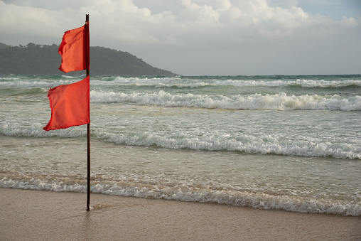 Red Flag on Beach Marking unsafe Water for Swimming