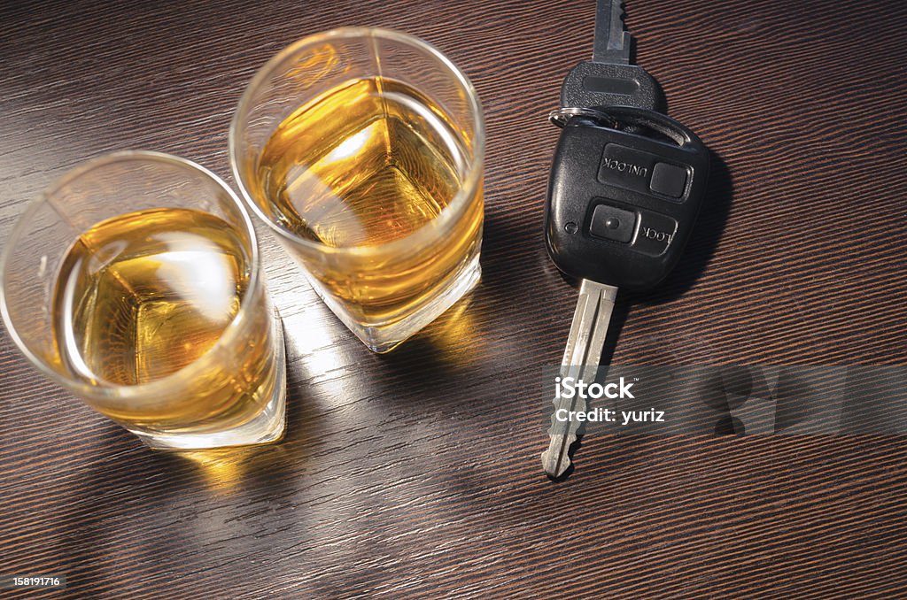 drunk driving two whiskey shots on the bar counter with car key between them; focus on key Addiction Stock Photo