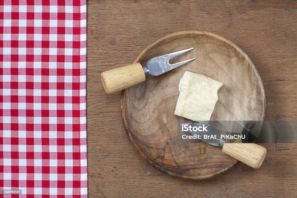 Obrus, parmezan i nóż w płytkę na drewnianym stole - Zbiór zdjęć royalty-free (Czerwony)