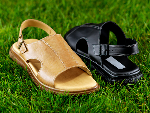 Chic leather men’s sandals on grass