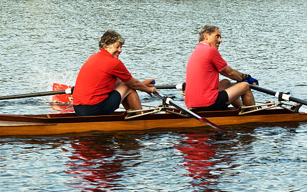 due persone o sculling una gara di canottaggio barca - canoeing canoe senior adult couple foto e immagini stock