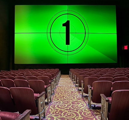 Large green screen with countdown in a classical style chic  movie theater