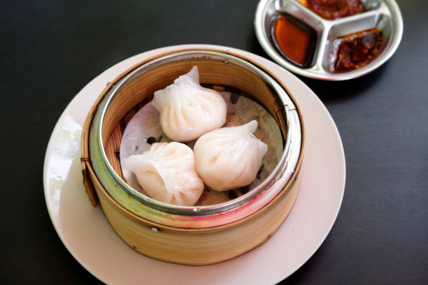 istock Chinese dim sum 'Hagao' in bamboo basket on black table 1581988554