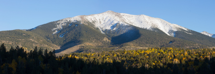 The first snow fall of the season covers the San Francisco Peaks as the aspen trees still glow in gold near Flagstaff, Arizona.