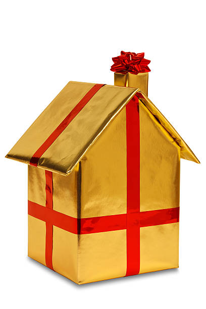 New home wrapped in gold paper with ribbon and bow stock photo