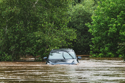 A vehicle sits in deep water after a river overflows following record breaking rainfall.