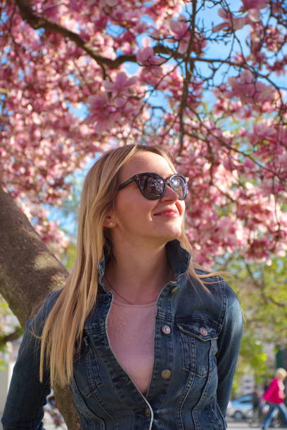 istock Woman standing in front of cherry tree 1582009628