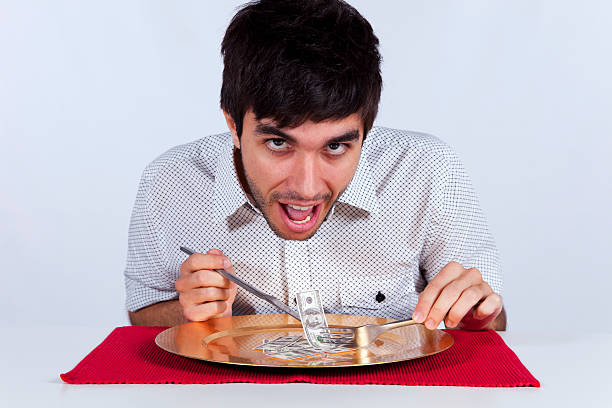 istock Man eating little dollar banknote 158201101
