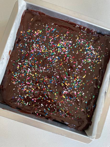 istock Frosted decadent brownies with sprinkles on top wait to be cut 1582013907