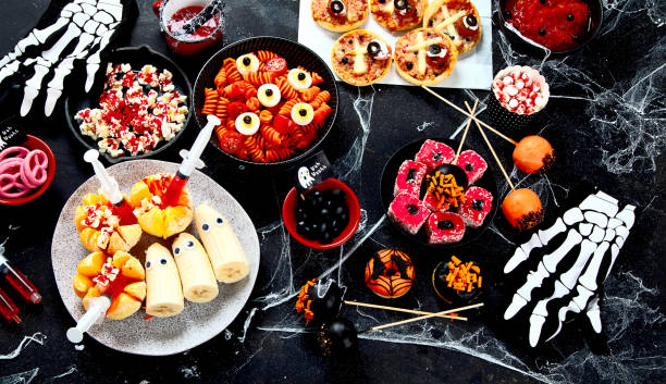 istock Halloween sweets for Halloween party on black background. top view 1582080125