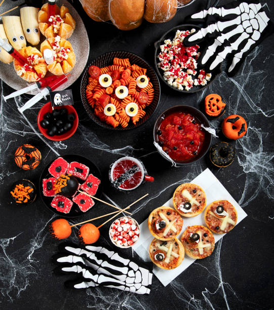 istock Halloween sweets for Halloween party on black background. top view 1582080139