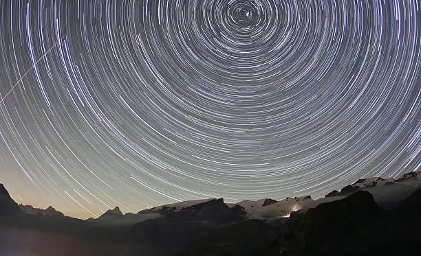 Startrail composed by 44 shots with north celestian pole and falling star on the left side. on left Cervino mountain and the MonteRosa glacier.