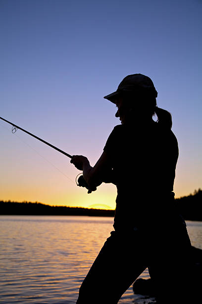 woman ジョンフィッシングの夕暮れ - fisherwoman ストックフォトと画像