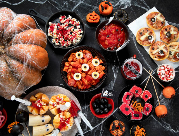 istock Halloween sweets for Halloween party on black background. top view 1582088066